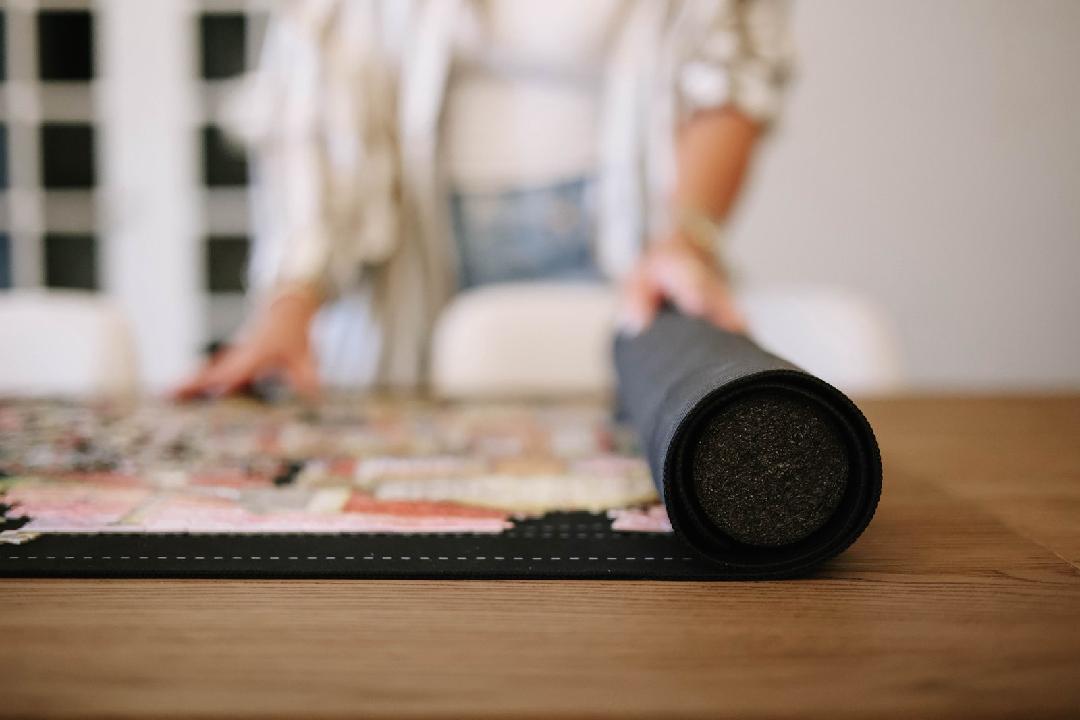 woman unrolling newverest puzzle mat roll-up